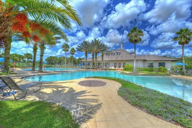 a view of a swimming pool with lounge chairs in patio