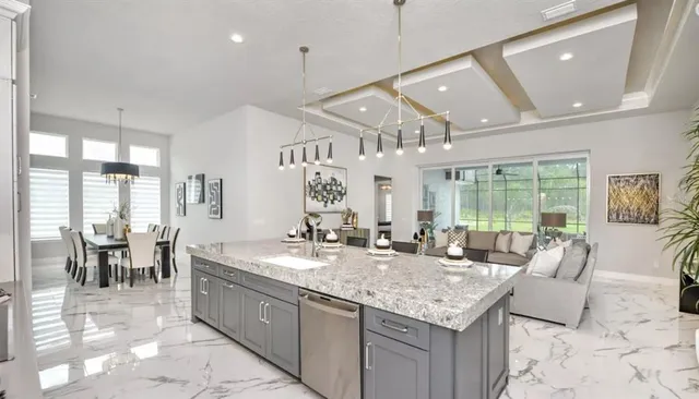 an open kitchen with granite countertop a sink and chandelier