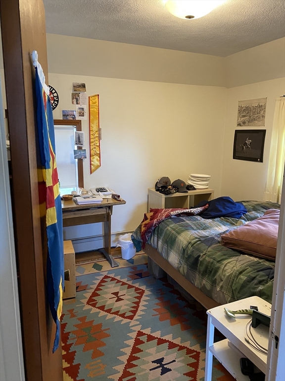 213 Holland Street, Unit R Somerville, MA 02144 - Photo 12 of 23 a bedroom with a bed and a flat screen tv