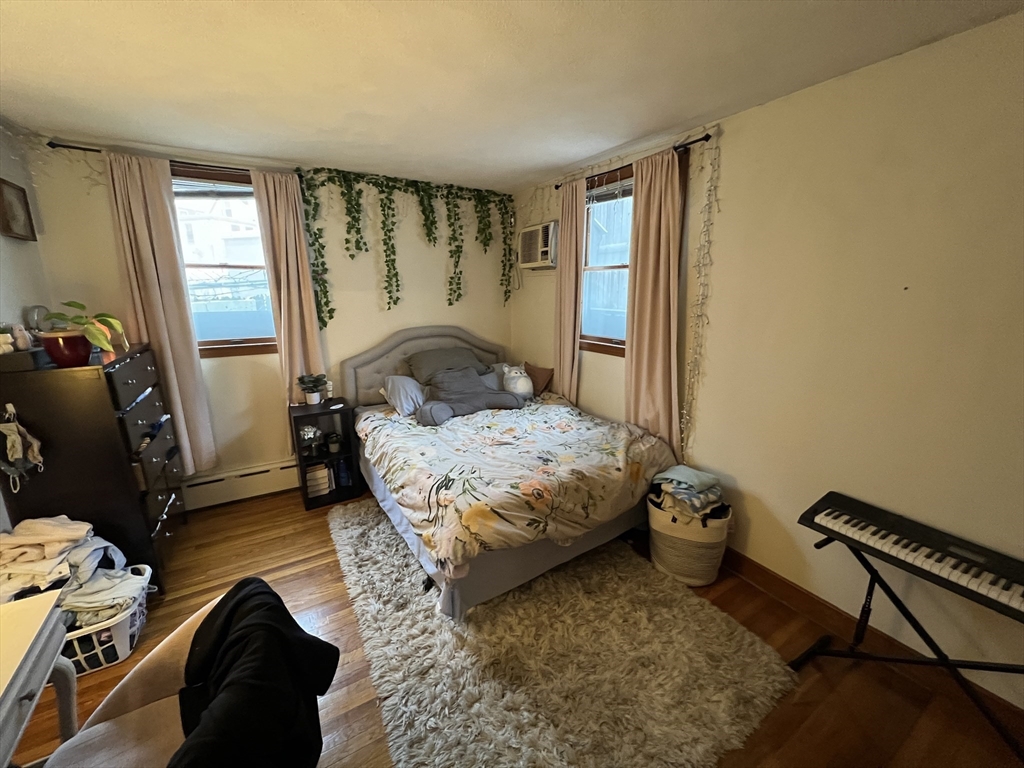 213 Holland Street, Unit R Somerville, MA 02144 - Photo 15 of 23 a bedroom with a bed and wooden floor