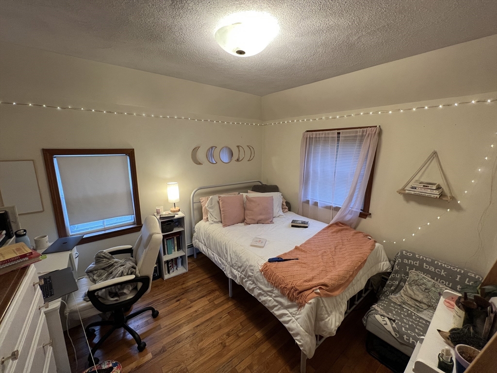 213 Holland Street, Unit R Somerville, MA 02144 - Photo 16 of 23 a bed room with a bed and a mirror