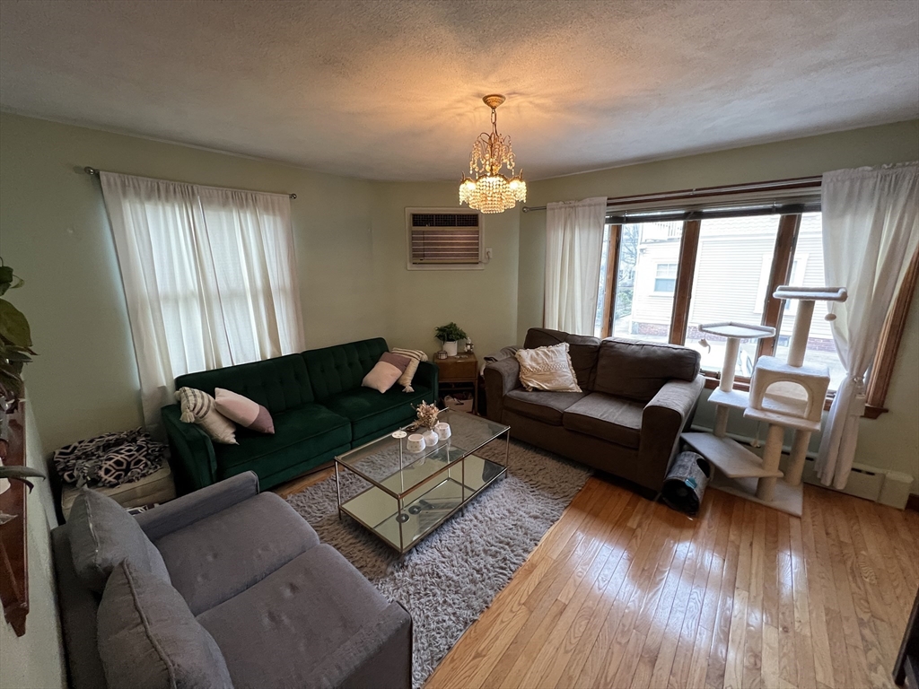 213 Holland Street, Unit R Somerville, MA 02144 - Photo 2 of 23 a living room with furniture wooden floor and a lamp