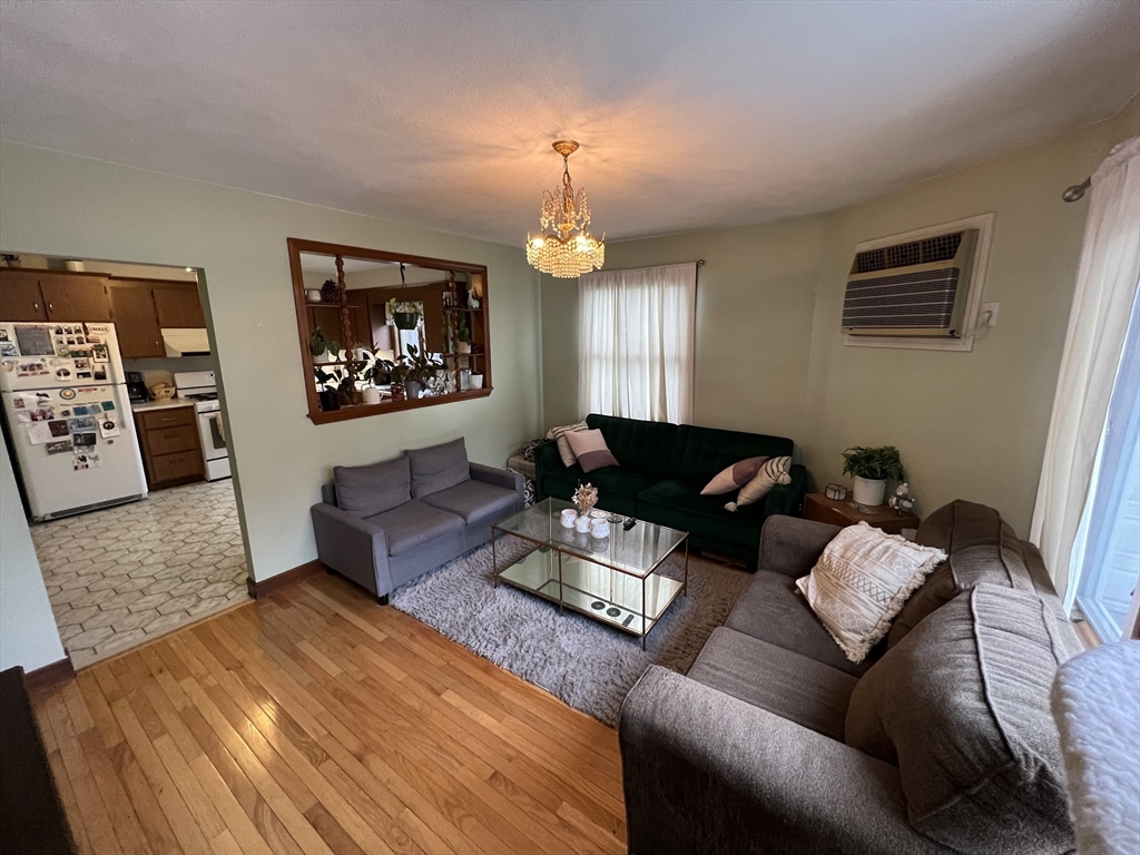 213 Holland Street, Unit R Somerville, MA 02144 - Photo 3 of 23 a living room with furniture a chandelier and a window