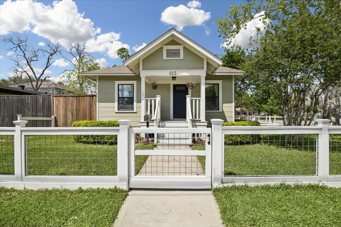 a front view of a house with a garden and plants
