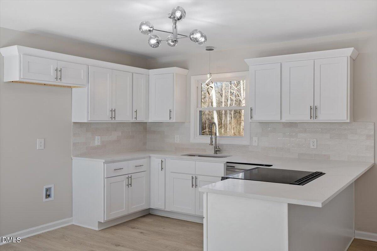 5326 Salem Church Road Graham, NC 27253 - Photo 7 of 20 a kitchen with a sink dishwasher and white cabinets with wooden floor