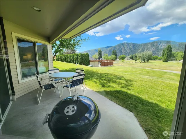 a view of a swimming pool with lawn chairs under an umbrella
