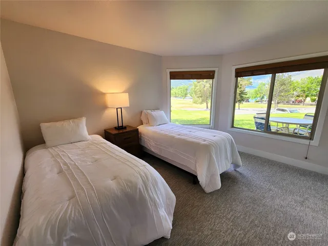 a bedroom with two beds and a large window