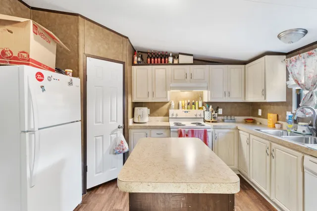 a kitchen with a refrigerator a stove top oven a sink and cabinets