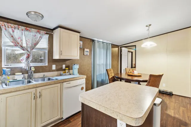 a kitchen with a table chairs sink and cabinets
