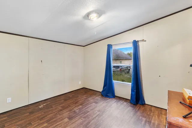 a view of an empty room with wooden floor