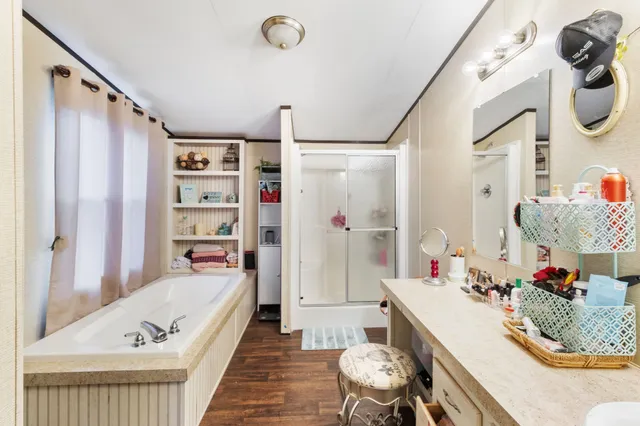 a bathroom with a granite countertop tub sink and mirror
