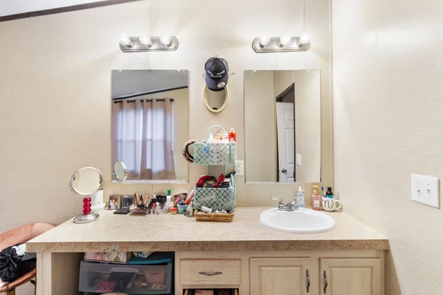 a bathroom with a granite countertop sink and a mirror