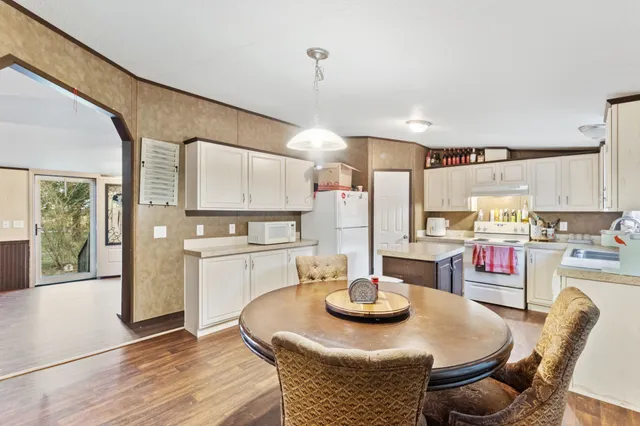 a kitchen with stainless steel appliances granite countertop a kitchen island a stove a table and chairs