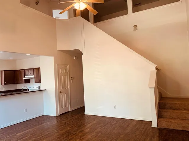 a view of a kitchen with wooden floor and a hallway