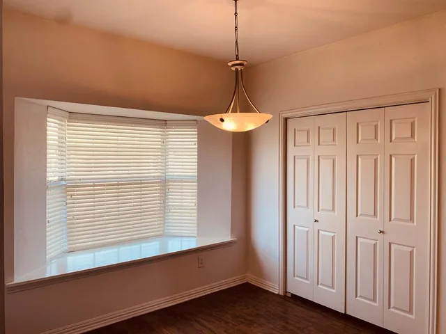 a view of a room with a window and wooden floor