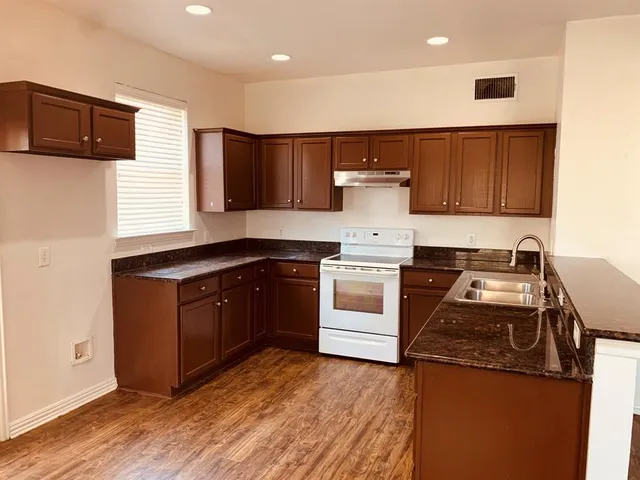 a kitchen with a sink and a stove top oven