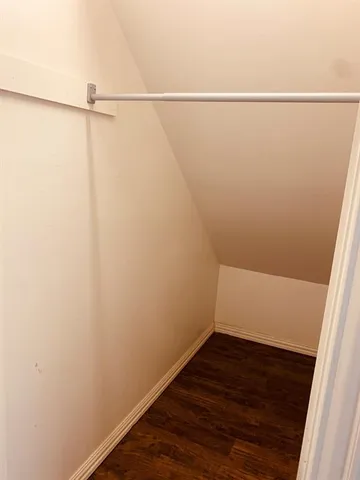 a view of small space with racks on the wall and a window