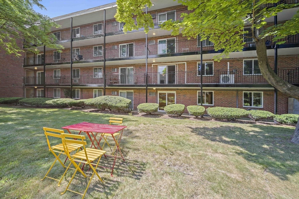 50 Green Street, Unit 108 Brookline, MA 02446 - Photo 20 of 22 a backyard of a house with barbeque oven table and chairs