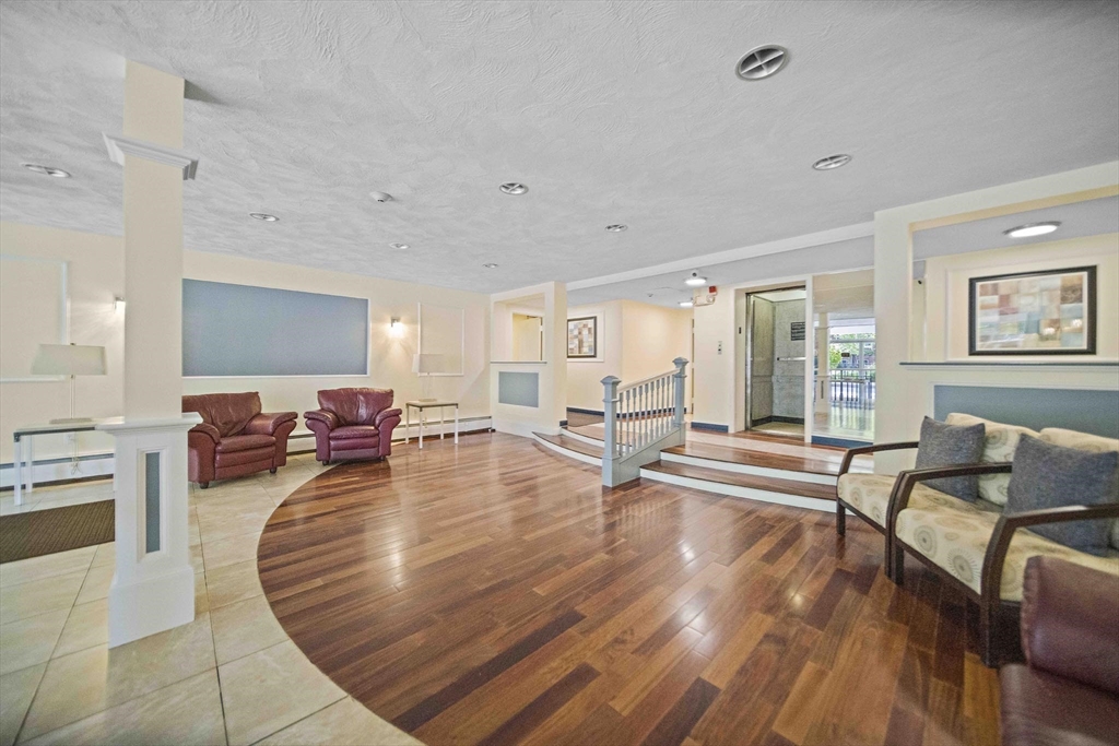 50 Green Street, Unit 108 Brookline, MA 02446 - Photo 3 of 22 a living room with furniture and a wooden floor