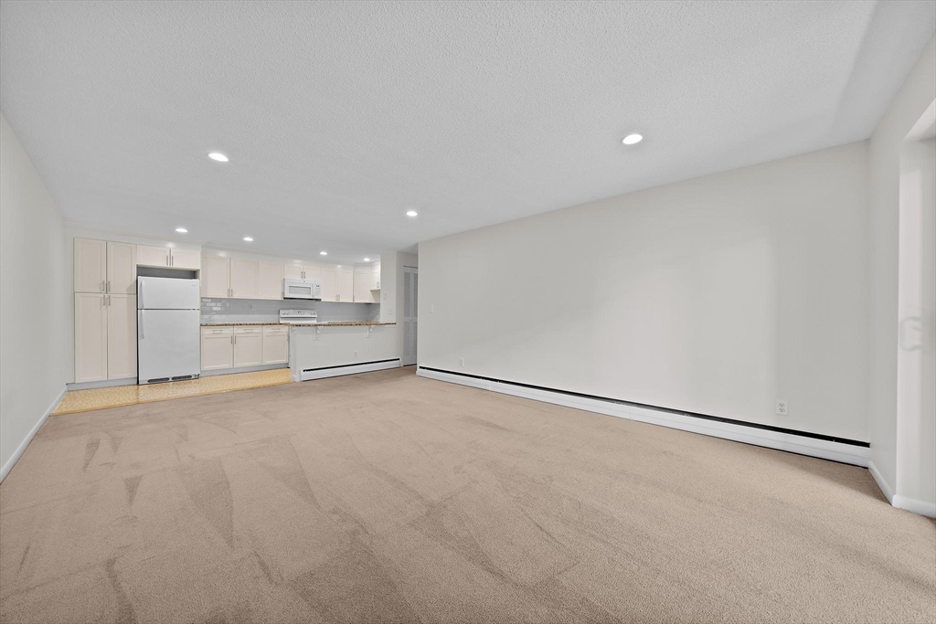 50 Green Street, Unit 108 Brookline, MA 02446 - Photo 7 of 22 a view of an empty room with a kitchen