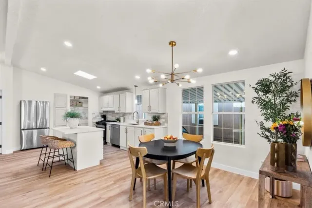 a view of a dining room and livingroom with furniture wooden floor a chandelier