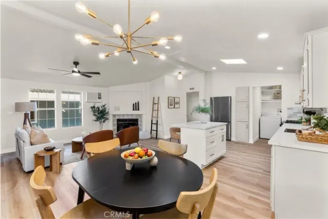 a living room with furniture kitchen view and a chandelier