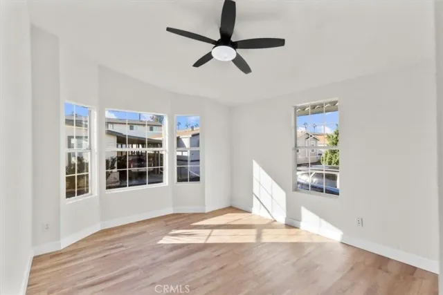 a view of a livingroom with wooden floor and a ceiling fan