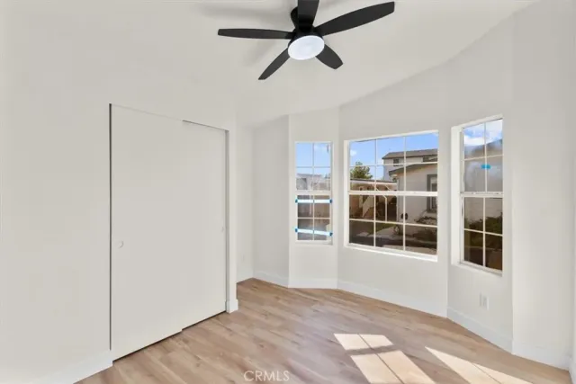a view of empty room with wooden floor and windows