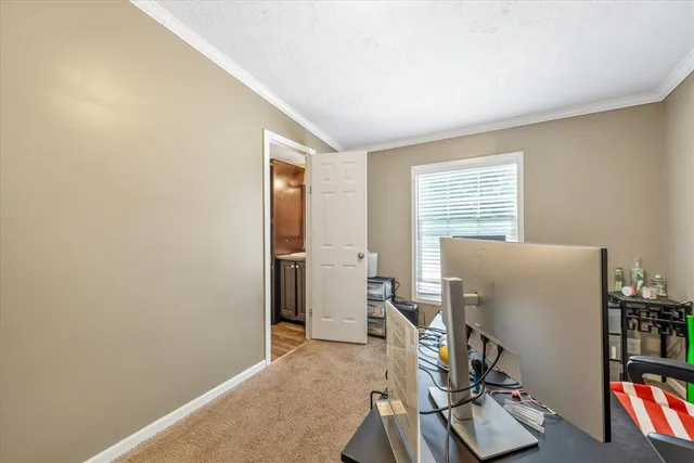 a view of a workspace with furniture and a window