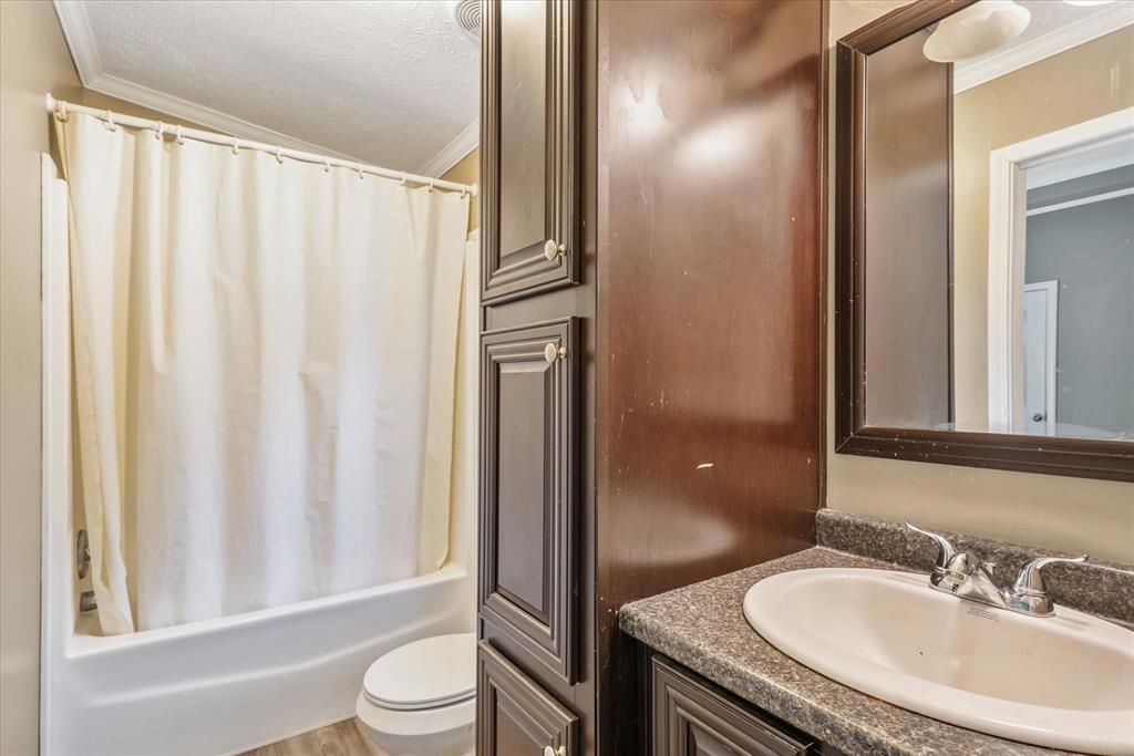 13902 East Travis Lane Log Cabin, TX 75148 - Photo 14 of 24 a bathroom with a granite countertop sink toilet and shower