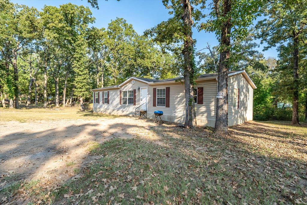 13902 East Travis Lane Log Cabin, TX 75148 - Photo 22 of 24 a front view of a house with a yard and garage