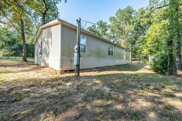 a view of a house with backyard and a tree