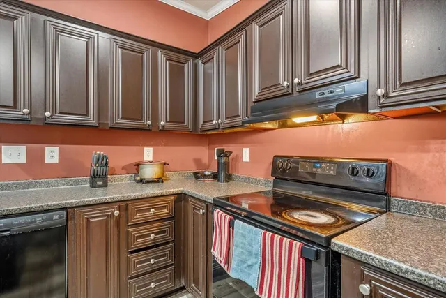a kitchen with stainless steel appliances granite countertop a stove a sink dishwasher and cabinets with wooden floor