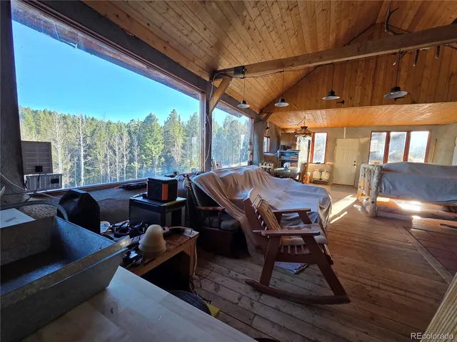 a living room with furniture a wooden floor and next to a window