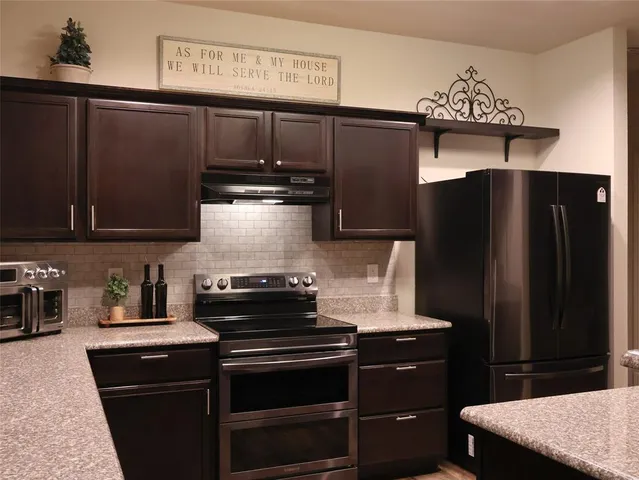 a kitchen with stainless steel appliances granite countertop a refrigerator and a stove