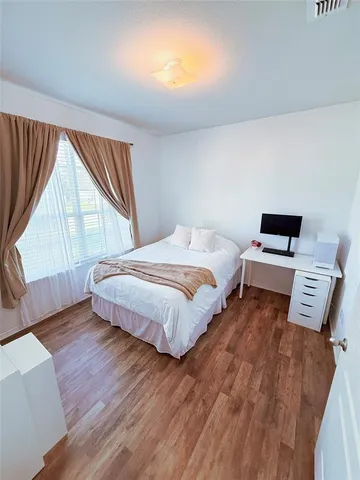 a bedroom with a bed and wooden floor