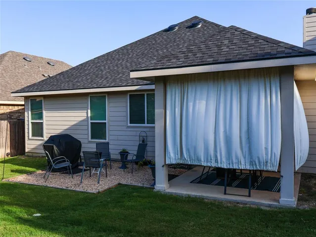 a view of backyard with table and chairs and potted plants