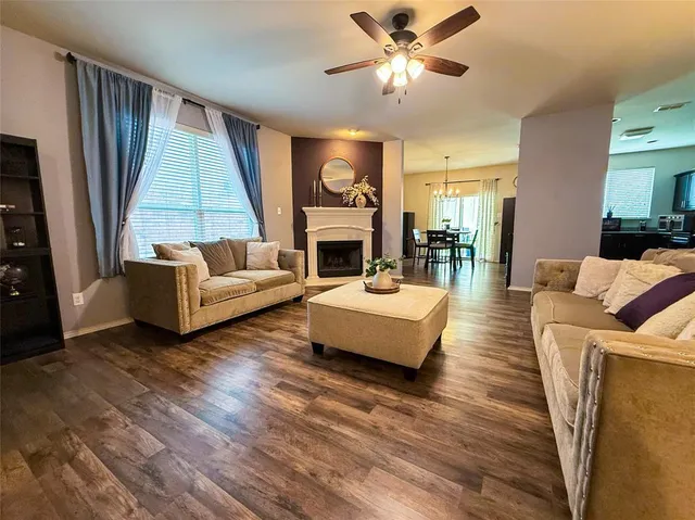 a living room with fireplace furniture and a wooden floor