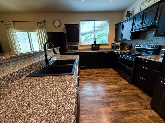 a kitchen with a sink and a stove top oven