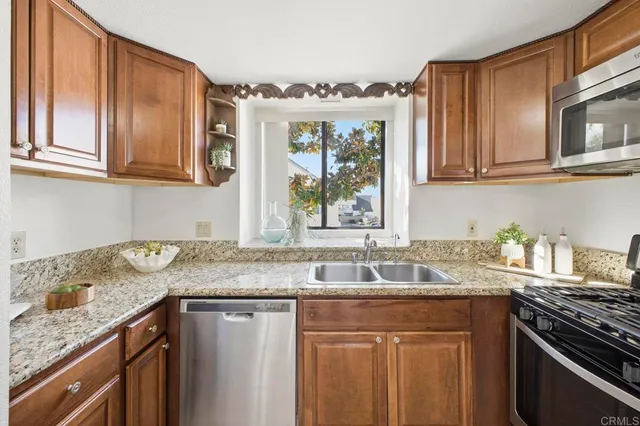 a kitchen with granite countertop a sink stove and cabinets