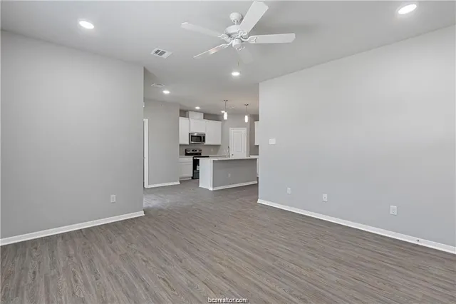 wooden floor in an empty room with a kitchen