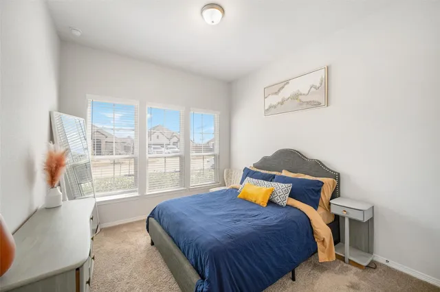 a bedroom with a bed and a large window