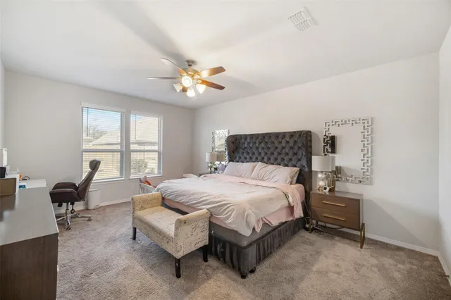 a bedroom with a bed and a large window