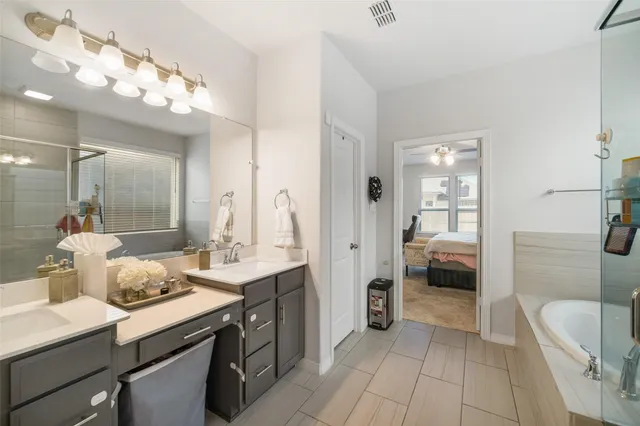 a bathroom with a tub sink and mirror