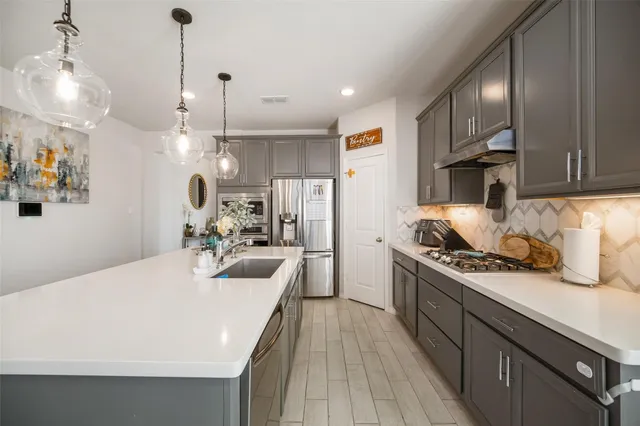 a kitchen with stainless steel appliances granite countertop a sink stove and refrigerator