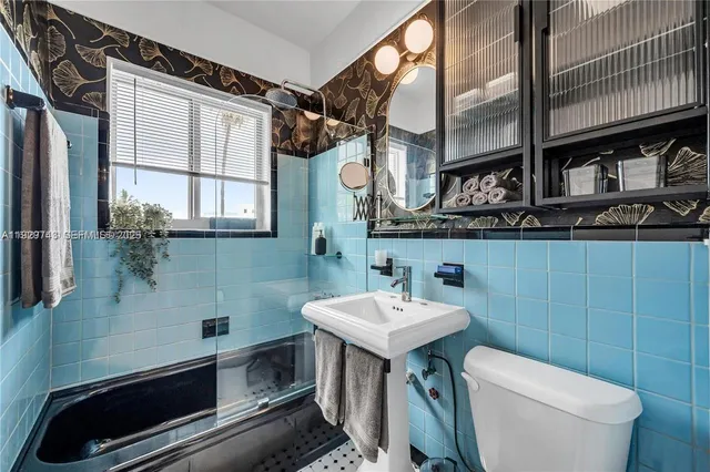 a bathroom with a sink a toilet and mirror