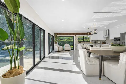 a large white kitchen with a large window and stainless steel appliances