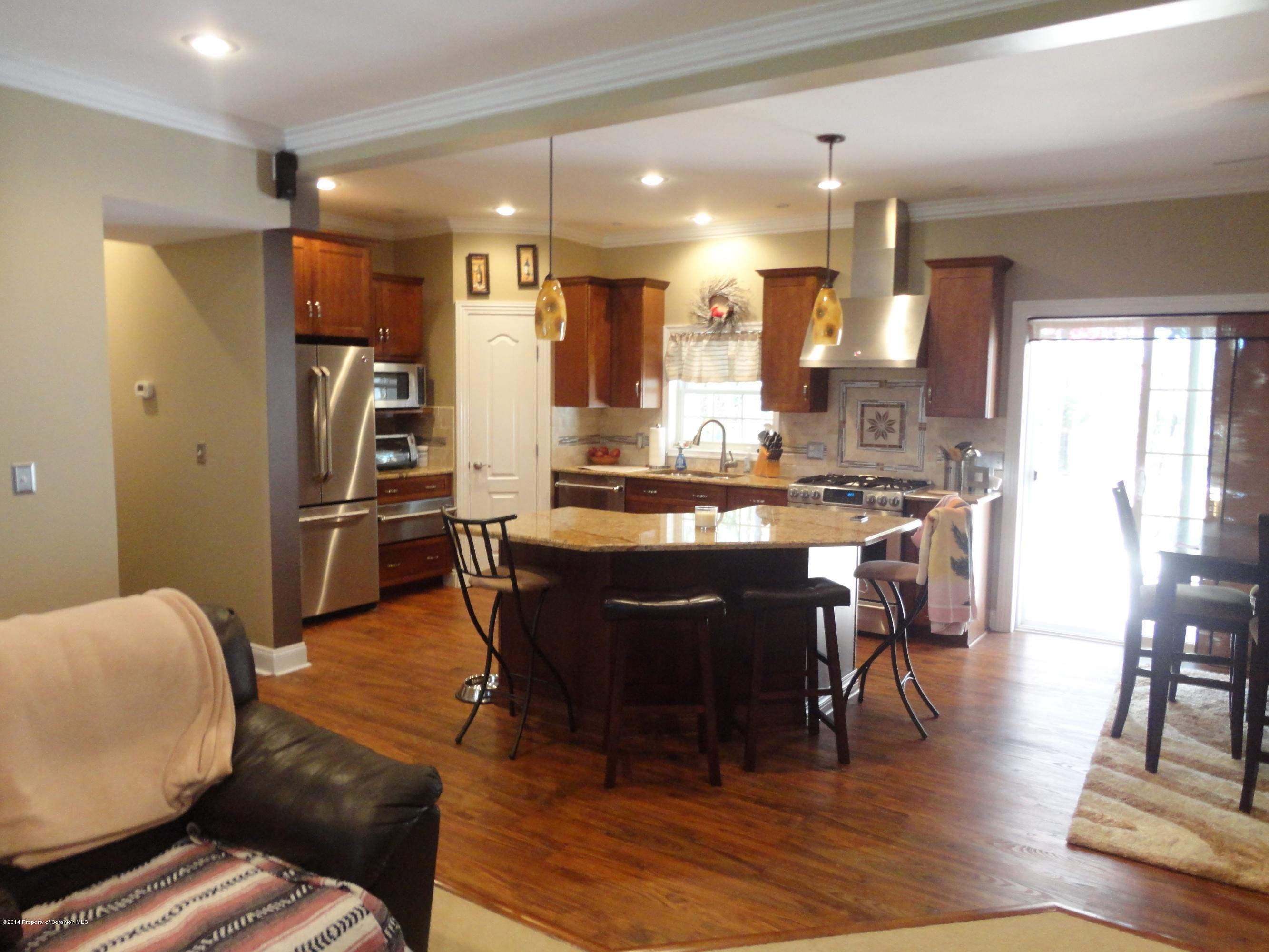 910 Line Road Lake Ariel, PA 18436 - Photo 17 of 48 a kitchen with stainless steel appliances kitchen island granite countertop a refrigerator a stove a sink and chairs