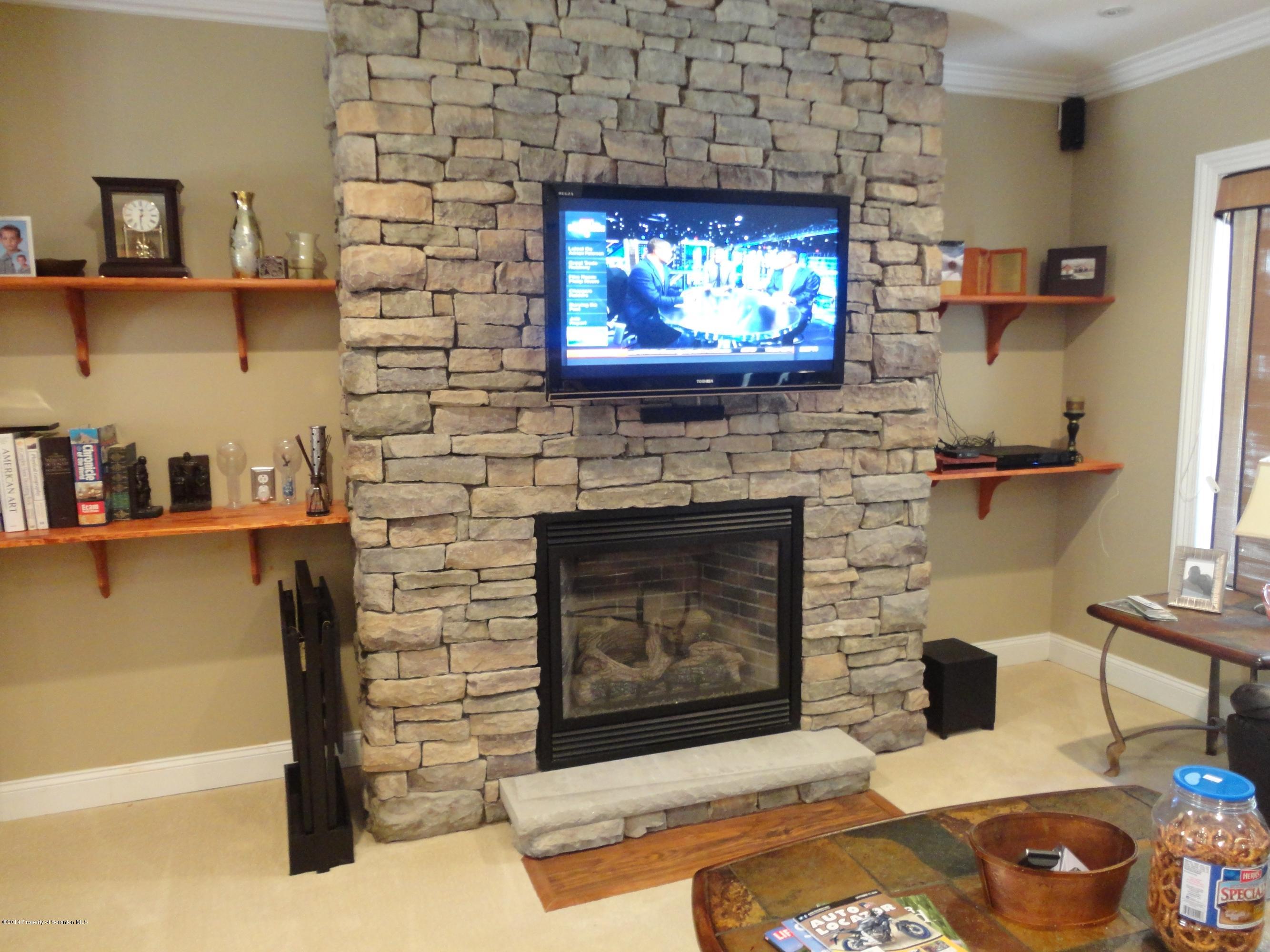 910 Line Road Lake Ariel, PA 18436 - Photo 24 of 48 a living room with a fireplace a flat screen tv and a fireplace