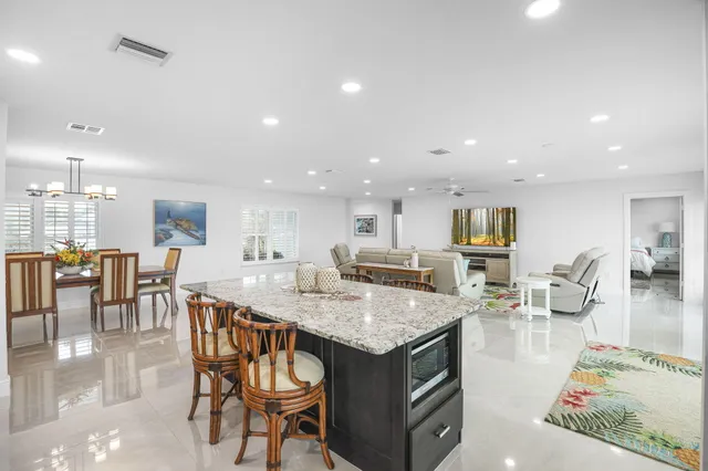 a bathroom with a granite countertop shower a mirror and a sink